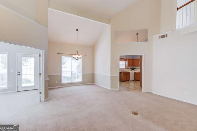 3585 Berkeley Park Ct, Duluth, GA 30096 - unfurnished living room with high vaulted ceiling, light colored carpet, a chandelier, and baseboards