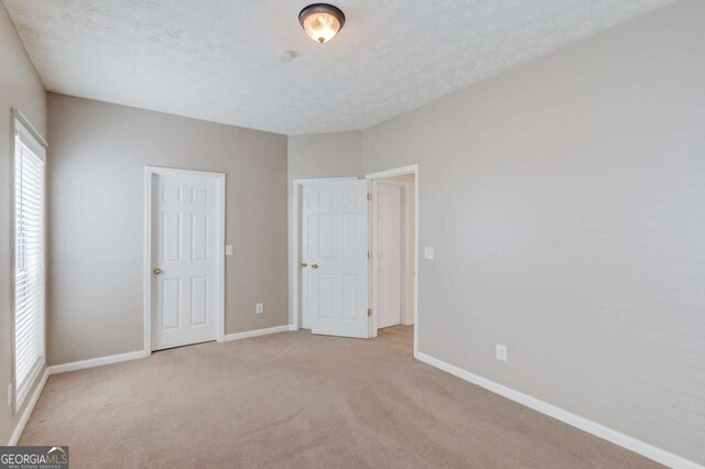 3585 Berkeley Park Ct, Duluth, GA 30096 - unfurnished bedroom featuring carpet flooring, baseboards, and a textured ceiling