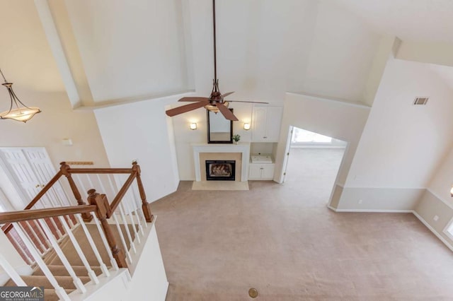 3585 Berkeley Park Ct, Duluth, GA 30096 - unfurnished living room featuring a high ceiling, a ceiling fan, light carpet, a fireplace with flush hearth, and stairway