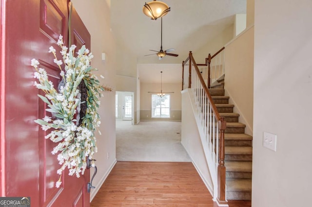 3585 Berkeley Park Ct, Duluth, GA 30096 - entryway featuring a towering ceiling, stairs, light wood-style floors, ceiling fan, and baseboards
