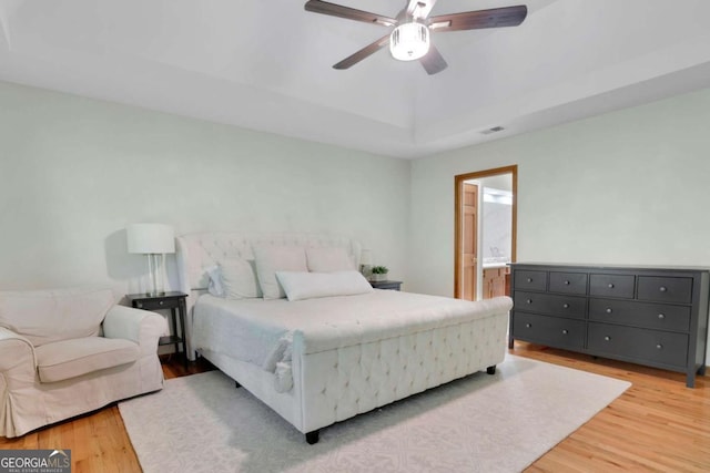 1925 Stonewyck Ct, Cumming, GA 30041 - bedroom with light wood-type flooring, a tray ceiling, ensuite bath, and ceiling fan