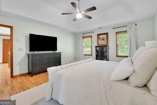 1925 Stonewyck Ct, Cumming, GA 30041 - bedroom featuring light wood finished floors, a raised ceiling, and a ceiling fan