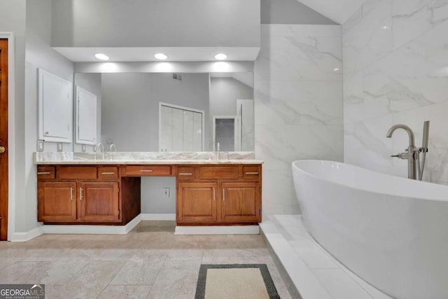 1925 Stonewyck Ct, Cumming, GA 30041 - bathroom with tile walls, a soaking tub, double vanity, recessed lighting, and vaulted ceiling
