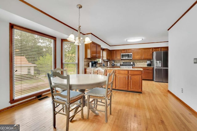 1925 Stonewyck Ct, Cumming, GA 30041 - dining area featuring light wood-type flooring, crown molding, and a chandelier