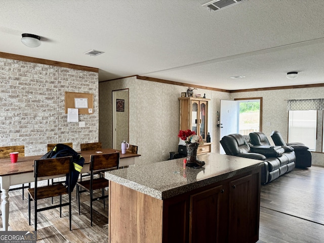 342 Wellington Dr, Byron, GA 31008 - kitchen featuring crown molding, a textured ceiling, light wood finished floors, open floor plan, and a kitchen island
