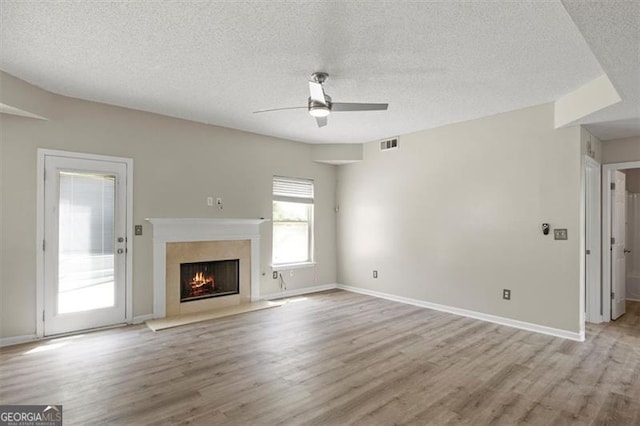 3385 Amhurst Pkwy, South Fulton, GA 30349 - unfurnished living room featuring light wood finished floors, a ceiling fan, a textured ceiling, a lit fireplace, and baseboards