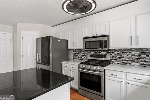 3385 Amhurst Pkwy, South Fulton, GA 30349 - kitchen featuring stainless steel appliances, white cabinets, decorative backsplash, and a textured ceiling