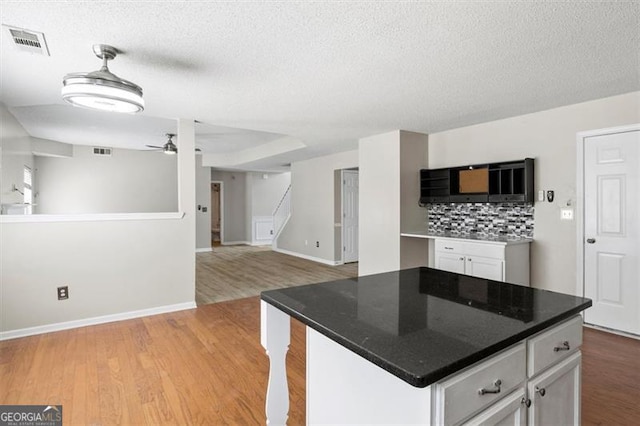 3385 Amhurst Pkwy, South Fulton, GA 30349 - kitchen with white cabinetry, light wood-style floors, baseboards, a ceiling fan, and a textured ceiling