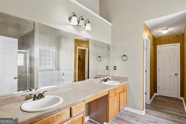 3385 Amhurst Pkwy, South Fulton, GA 30349 - bathroom featuring a garden tub, double vanity, wood finished floors, a shower stall, and baseboards
