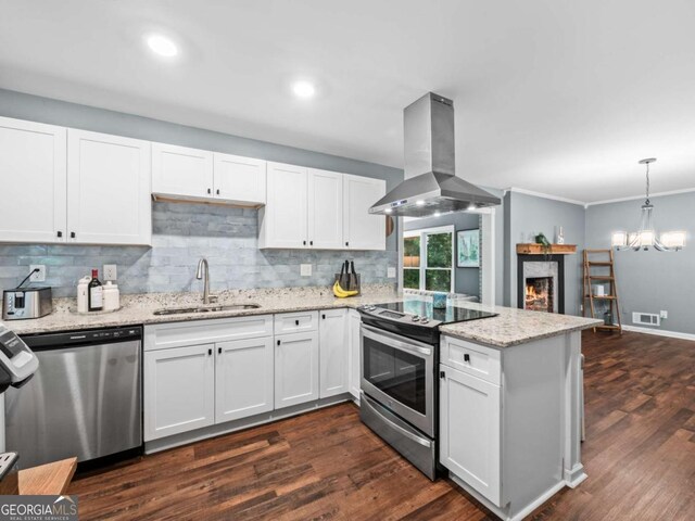 1488 Vine St NE, Gainesville, GA 30501 - kitchen with stainless steel appliances, a sink, island exhaust hood, a peninsula, and decorative backsplash