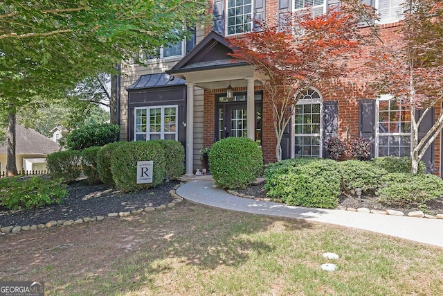 2295 Hemrick Rd, Cumming, GA 30041 - view of exterior entry featuring brick siding and a standing seam roof