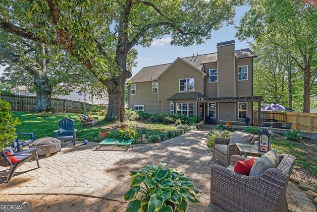 2295 Hemrick Rd, Cumming, GA 30041 - back of property featuring a fire pit, a patio, and a fenced backyard