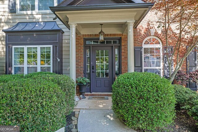 2295 Hemrick Rd, Cumming, GA 30041 - view of exterior entry featuring brick siding and a standing seam roof