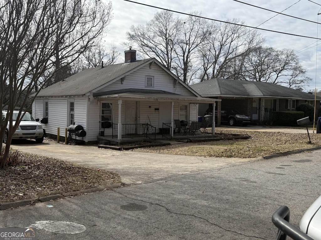1126 Wright St, Griffin, GA 30223 - view of front of home with driveway, a chimney, and a porch