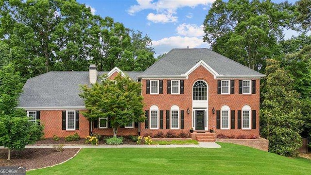 1206 Mountainside Trce NW, Kennesaw, GA 30152 - view of front facade with a front yard, brick siding, and a chimney