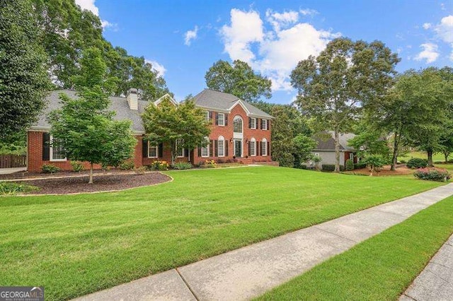 1206 Mountainside Trce NW, Kennesaw, GA 30152 - colonial home featuring a front lawn, brick siding, and a chimney