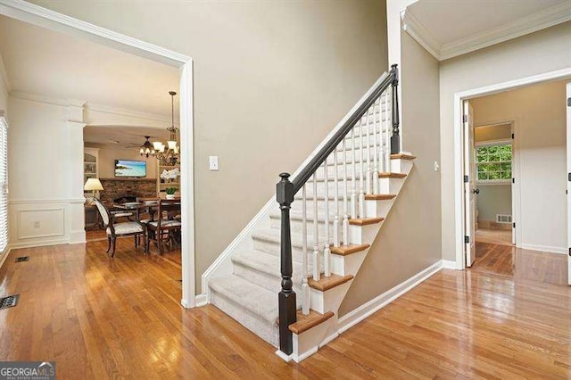 1206 Mountainside Trce NW, Kennesaw, GA 30152 - staircase featuring wood finished floors, crown molding, a chandelier, and baseboards