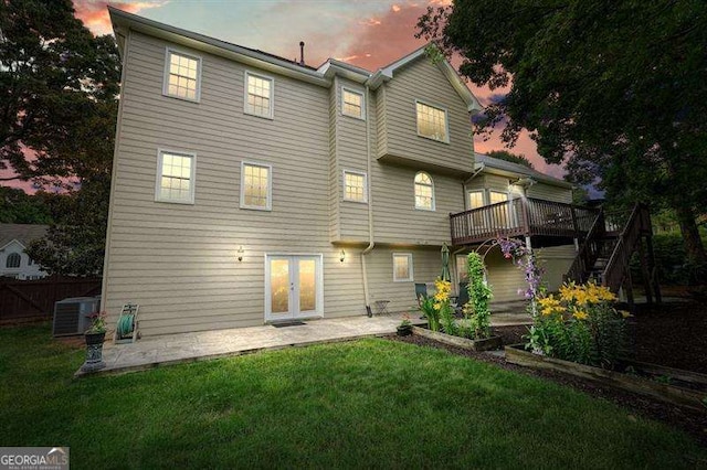 1206 Mountainside Trce NW, Kennesaw, GA 30152 - back of house at dusk featuring a wooden deck, a patio area, a yard, central AC, and stairway