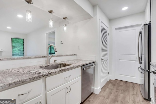 206 Tuxworth Cir, Decatur, GA 30033 - kitchen with a sink, stainless steel appliances, white cabinets, light wood-style flooring, and light stone countertops