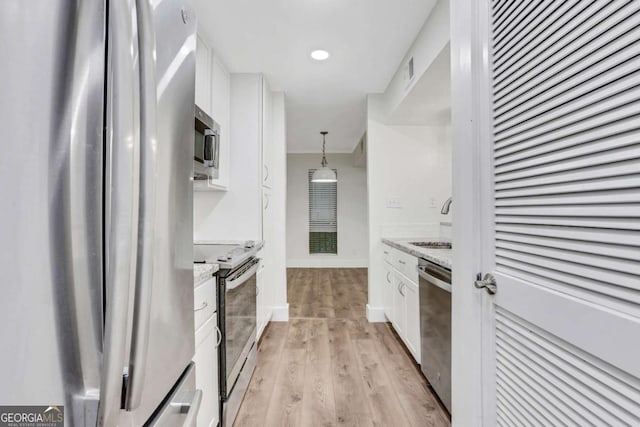 206 Tuxworth Cir, Decatur, GA 30033 - kitchen with appliances with stainless steel finishes, white cabinetry, a sink, light wood finished floors, and baseboards