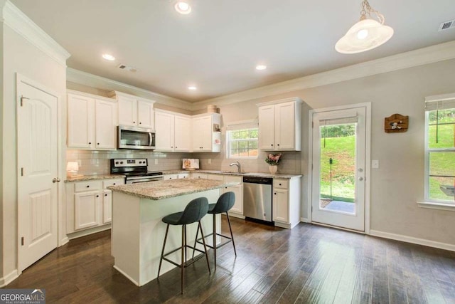 1300 Jefferson Walk Cir, Jefferson, GA 30549 - kitchen with appliances with stainless steel finishes, crown molding, plenty of natural light, white cabinetry, and recessed lighting