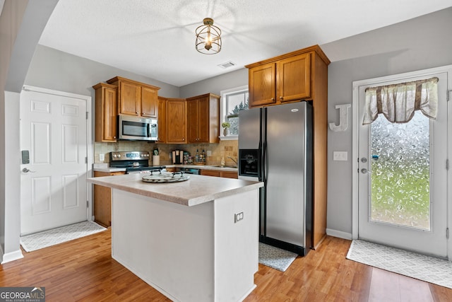 106 Thornton Dr, Bonaire, GA 31005 - kitchen featuring stainless steel appliances, light countertops, light wood-style flooring, decorative backsplash, and a sink