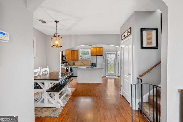 106 Thornton Dr, Bonaire, GA 31005 - dining space with light wood finished floors, arched walkways, and stairway