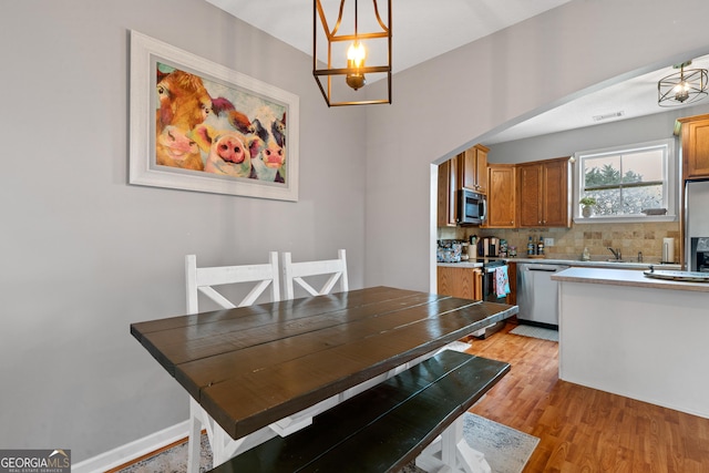 106 Thornton Dr, Bonaire, GA 31005 - dining area featuring light wood-style floors, arched walkways, and a chandelier