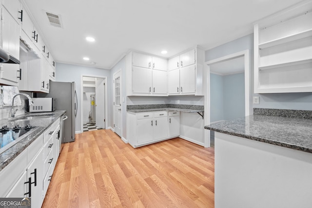 3047 Hudson Ct, Decatur, GA 30033 - kitchen with white cabinets, crown molding, light wood-type flooring, recessed lighting, and black electric stovetop