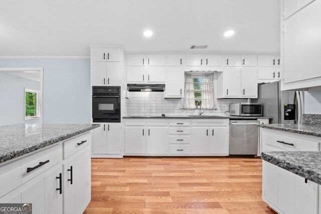 3047 Hudson Ct, Decatur, GA 30033 - kitchen featuring black appliances, under cabinet range hood, ornamental molding, tasteful backsplash, and light wood-type flooring
