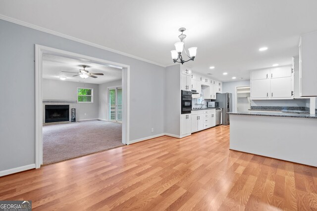 3047 Hudson Ct, Decatur, GA 30033 - kitchen with stainless steel appliances, dark countertops, a chandelier, white cabinetry, and ornamental molding