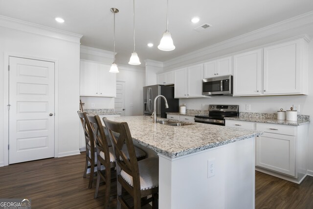 22 Mossy Oaks Ln NE, Rome, GA 30165 - kitchen with stainless steel appliances, dark wood finished floors, a center island with sink, white cabinets, and ornamental molding