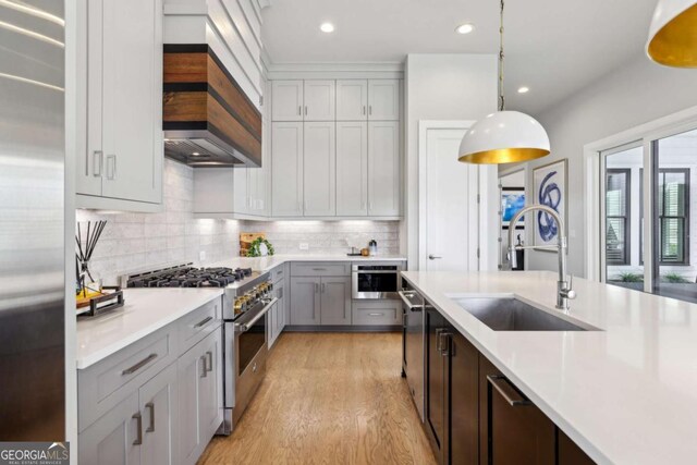 6815 Halcyon Way, Alpharetta, GA 30005 - kitchen with high end appliances, a sink, custom range hood, light countertops, and light wood-style flooring