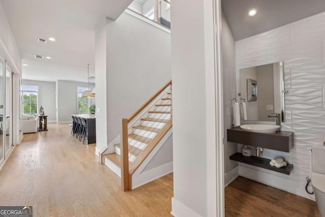 6815 Halcyon Way, Alpharetta, GA 30005 - corridor with a sink, light wood finished floors, recessed lighting, stairway, and baseboards