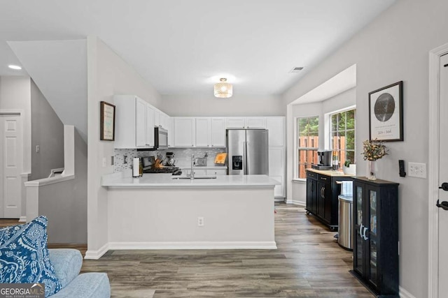 2061 Pinnacle Pointe Dr, Norcross, GA 30071 - kitchen featuring stainless steel refrigerator with ice dispenser, a sink, stove, light countertops, and a peninsula