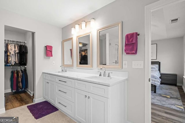 2061 Pinnacle Pointe Dr, Norcross, GA 30071 - bathroom with double vanity, ensuite bath, baseboards, wood finished floors, and a walk in closet
