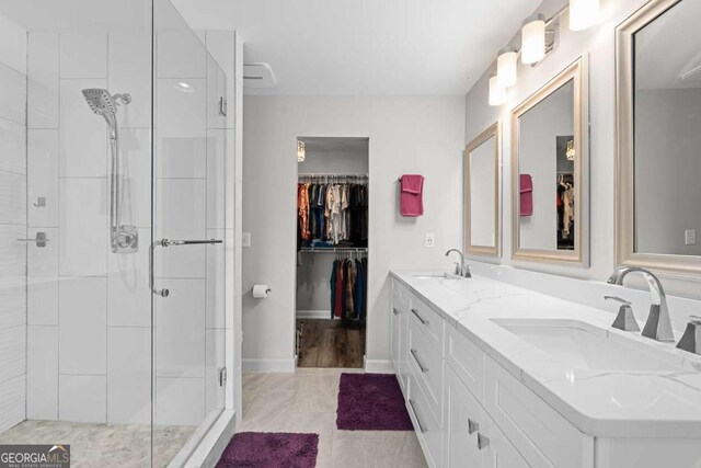 2061 Pinnacle Pointe Dr, Norcross, GA 30071 - bathroom featuring a shower stall, double vanity, a walk in closet, and tile patterned floors