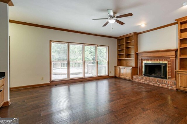 214 Jamestown Ave, Jonesboro, GA 30236 - unfurnished living room with a brick fireplace, ceiling fan, ornamental molding, built in shelves, and dark wood-type flooring