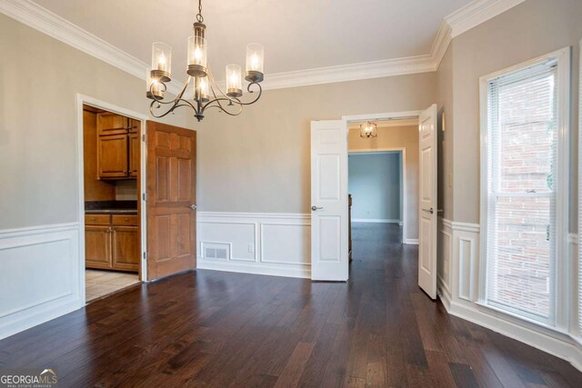 214 Jamestown Ave, Jonesboro, GA 30236 - unfurnished dining area featuring a chandelier, crown molding, dark wood-style floors, a wainscoted wall, and a decorative wall