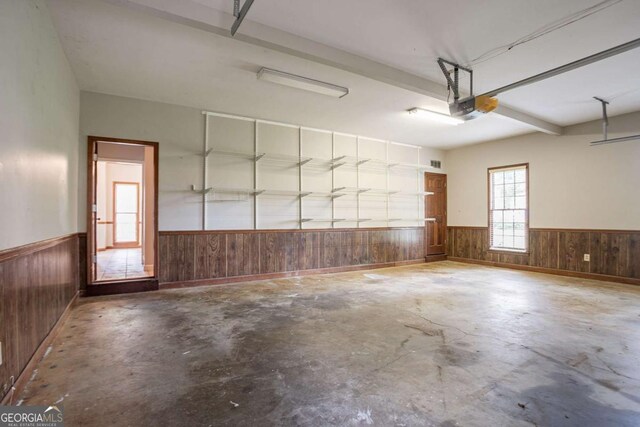 214 Jamestown Ave, Jonesboro, GA 30236 - garage with wainscoting, wooden walls, and a garage door opener