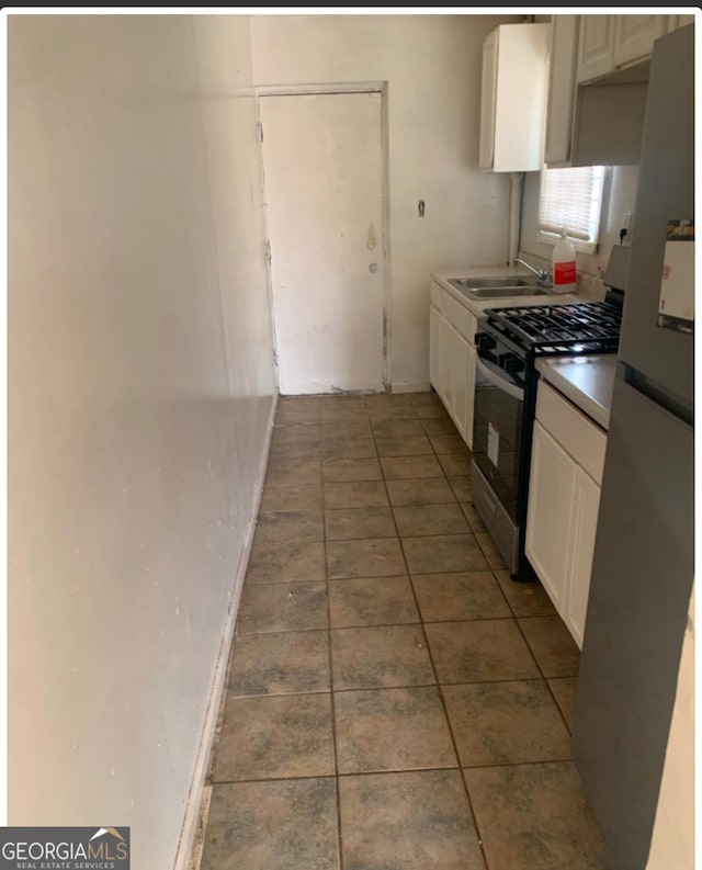 1129 Windsor St SW, Atlanta, GA 30310 - kitchen featuring stainless steel appliances, white cabinets, a sink, and tile patterned flooring