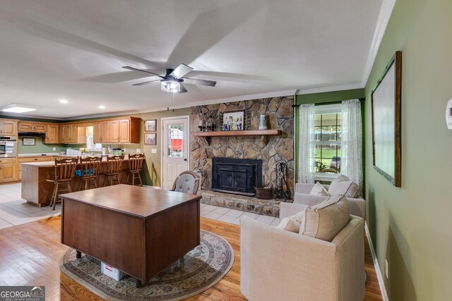 75 Barber Rd, Carrollton, GA 30116 - living room with crown molding, ceiling fan, a stone fireplace, light wood-style flooring, and baseboards