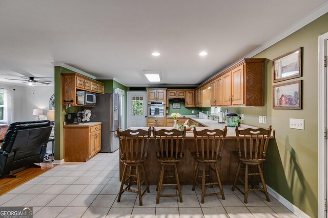 75 Barber Rd, Carrollton, GA 30116 - kitchen with stainless steel appliances, a peninsula, a sink, ornamental molding, and a breakfast bar area