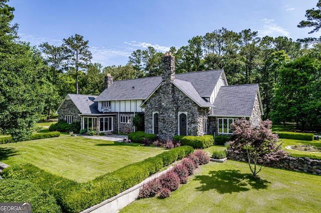 3090 Bethany Church Rd, Greensboro, GA 30642 - english style home featuring stone siding, board and batten siding, a front lawn, and a chimney