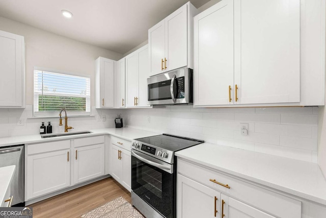 228 Whitneys Way, Dallas, GA 30157 - kitchen featuring appliances with stainless steel finishes, white cabinetry, backsplash, light wood finished floors, and recessed lighting