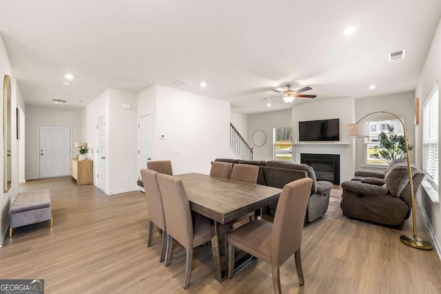 228 Whitneys Way, Dallas, GA 30157 - dining space with light wood-type flooring, a ceiling fan, recessed lighting, a glass covered fireplace, and stairway