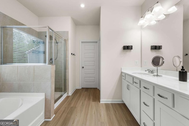 228 Whitneys Way, Dallas, GA 30157 - full bathroom featuring vanity, a stall shower, a garden tub, wood finished floors, and recessed lighting