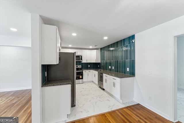 2310 Toussaint Ave, Savannah, GA 31404 - kitchen featuring appliances with stainless steel finishes, white cabinetry, recessed lighting, light marble finish flooring, and decorative backsplash