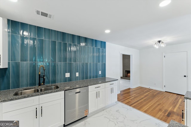 2310 Toussaint Ave, Savannah, GA 31404 - kitchen featuring stainless steel dishwasher, a fireplace, dark stone countertops, and recessed lighting