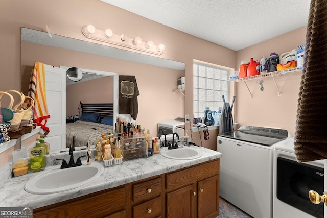 8436 Cyprus Ridge Way, Douglasville, GA 30134 - ensuite bathroom featuring washer and dryer, double vanity, and a textured ceiling